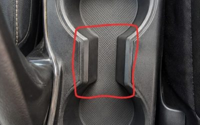 Wat is het doel van de vreemde afstand tussen de bekerhouders in de auto?